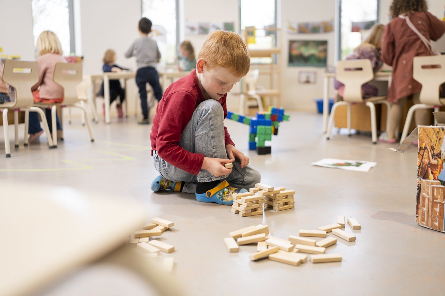 Leerling bouwt met houten blokken in de klas
