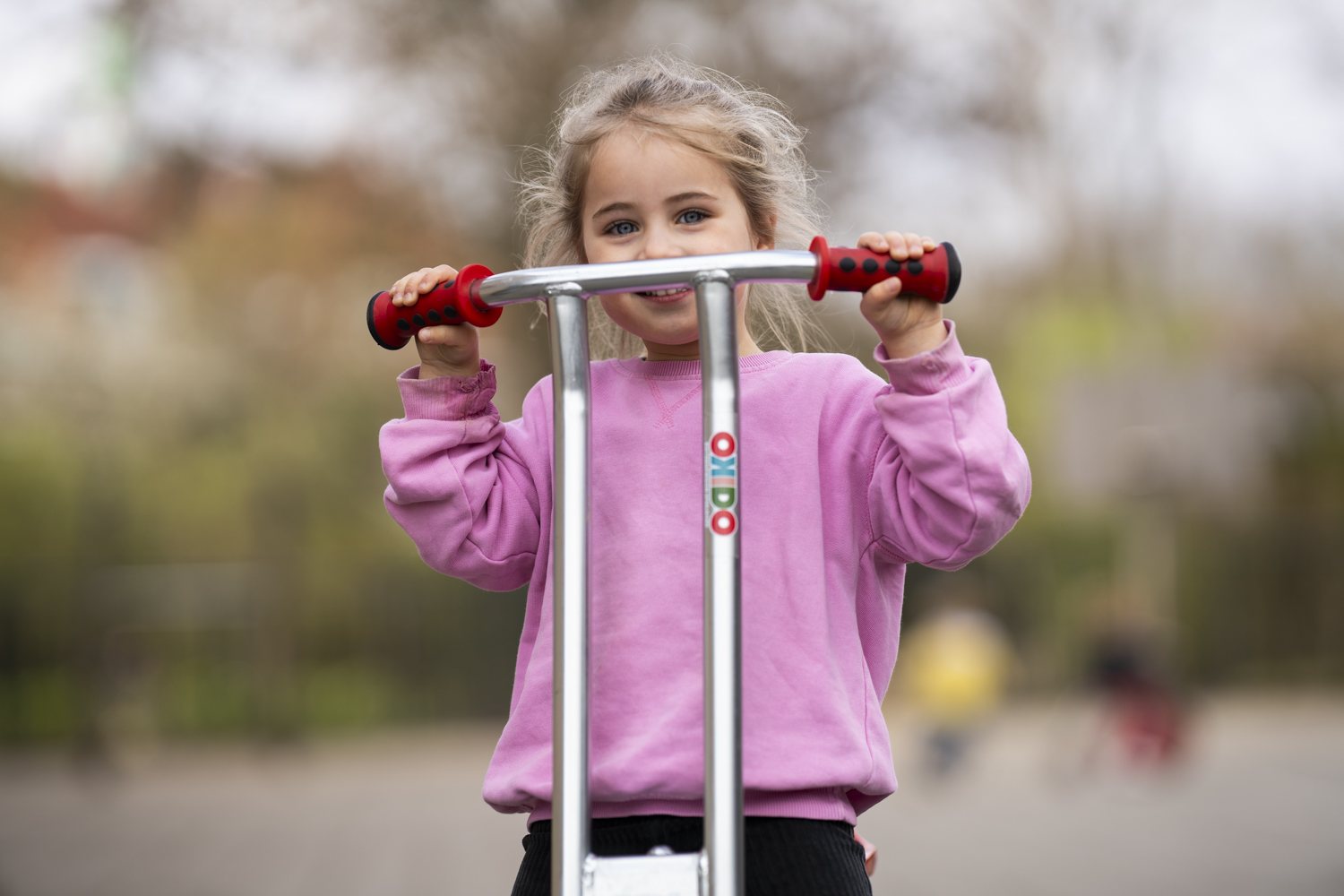 Meisje met step op het schoolplein