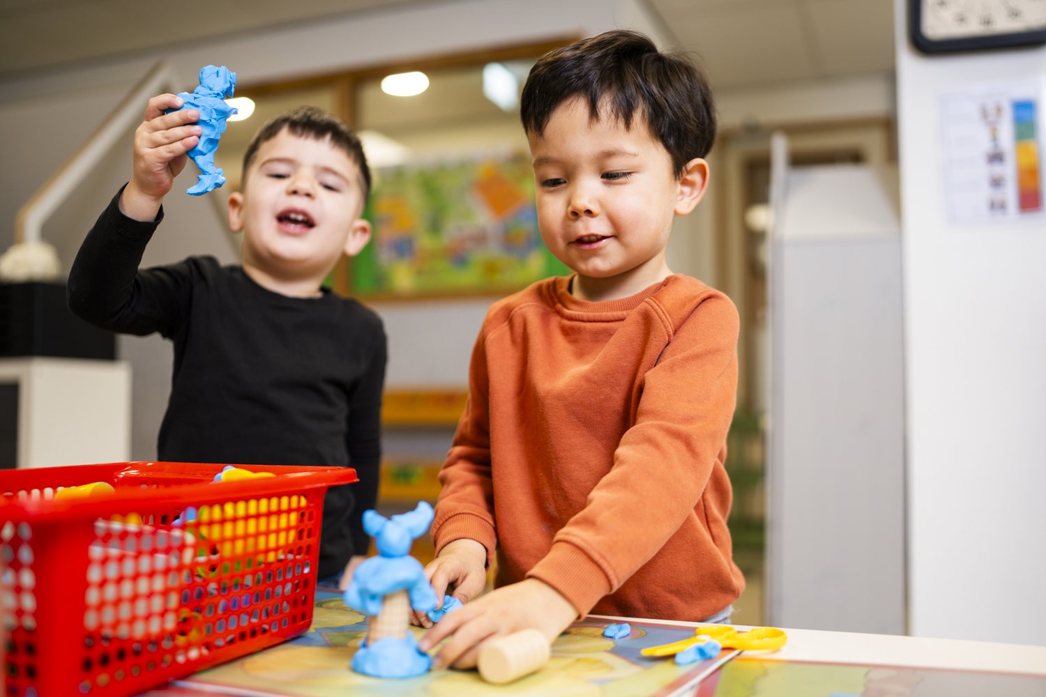Twee jongens spelen met blauwe klei