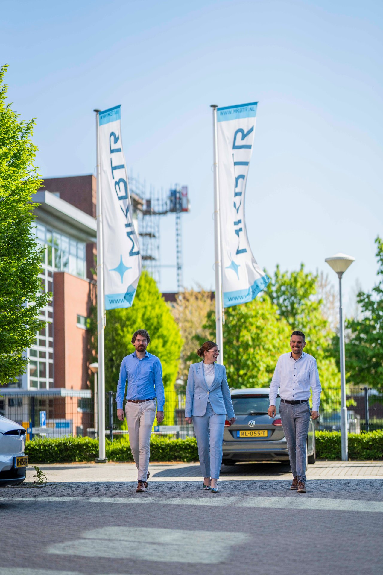 Collegas lopen onder de MKBTR-vlaggen naar binnen